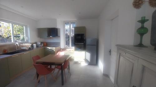 Il comprend une cuisine équipée d'une table et de chaises. dans l'établissement Location saisonnière gap hautes alpes, à Gap