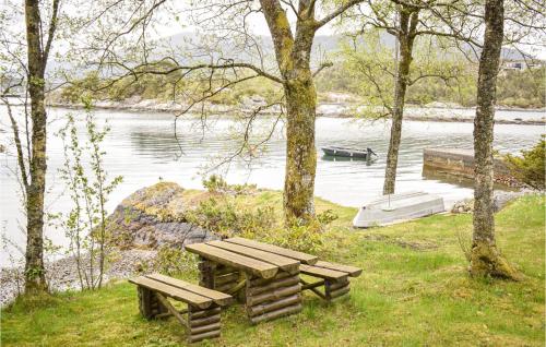 a picnic table and benches next to a body of water at 3 Bedroom Amazing Home In Skjold in Skjold