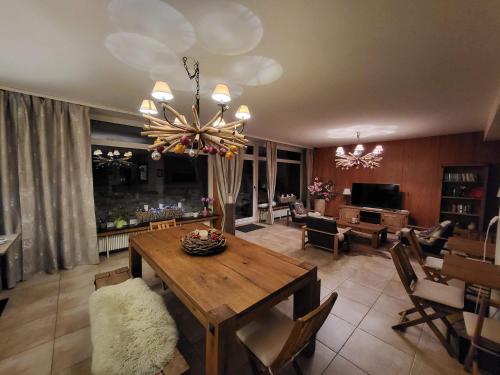 a living room with a wooden table and a chandelier at Ferienwohnung Parsenn Peaks Panorama in Davos