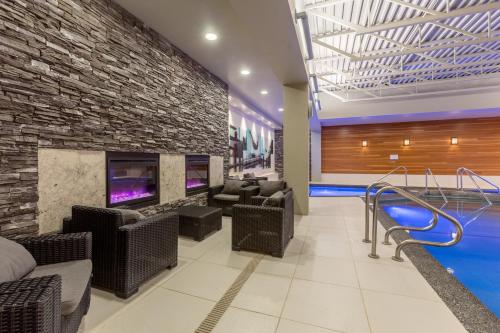 a lobby with a pool and chairs and a brick wall at Banff Park Lodge in Banff
