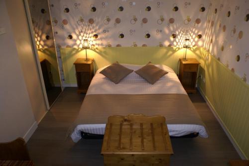Logis Hotel Restaurant Le Vedaquais في Vaas: غرفة نوم مع سرير مع مصباحين على الحائط