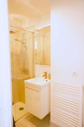 une salle de bain blanche avec un lavabo et une douche dans l'établissement Le Petit Félix, à 2 pas du lac & du centre ville, à Annecy