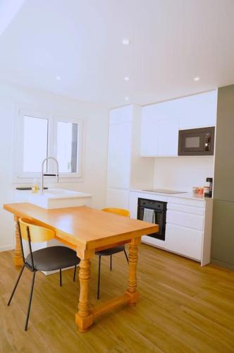 une cuisine avec une table en bois et deux chaises dans l'établissement Le Petit Félix, à 2 pas du lac & du centre ville, à Annecy