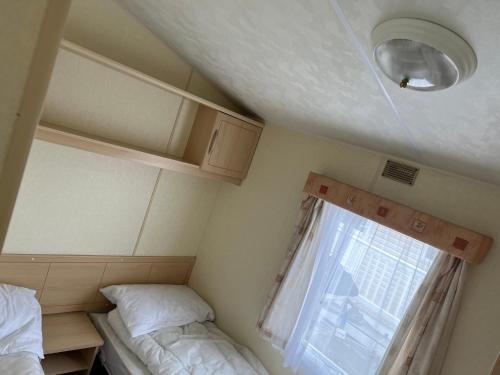 a small room with two beds and a window at Barmouth Sunnysands 204 in Talybont