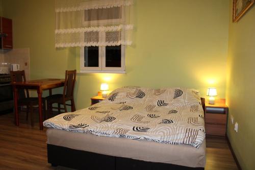 a bed in a room with a table and a kitchen at Apartament 2-pokojowy 55 m2, koło ZOO, Hali Stulecia in Wrocław