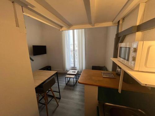 une petite cuisine avec une table et un micro-ondes dans l'établissement Le Studio de l'Opéra, à Montpellier