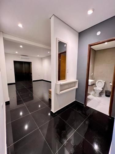 a bathroom with a toilet and a mirror at Che Kamba in Fernando de la Mora