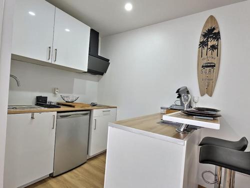 une cuisine avec des armoires blanches et des appareils électroménagers blancs dans l'établissement Cosy Des Rêves, à Villiers-sur-Marne