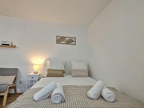ein Schlafzimmer mit einem Bett mit weißen Laken und Kissen in der Unterkunft Cosy Des Rêves in Villiers-sur-Marne