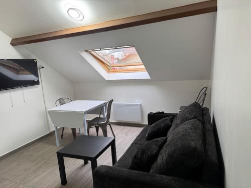 a living room with a couch and a table at Appartement J, RESIDENCE DU RENOUVEAU, Stade de France, idéal pour 4 pers in Saint-Denis