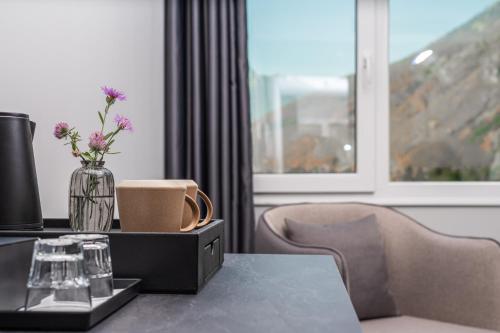 a table with a vase of flowers on top of it at Valbona Resort & Spa in Valbonë