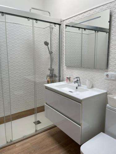 a bathroom with a sink and a glass shower at San Agustín BeachSun Relax in San Bartolomé
