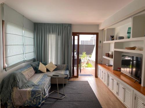 un soggiorno con un divano e una TV di San Agustín BeachSun Relax a San Bartolomé