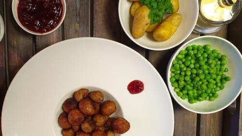 a table with plates of food with peas and potatoes at Évika boutique hotel in Eskilsby