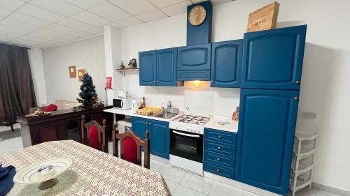 a kitchen with blue cabinets and a christmas tree at Rita House Cozy Stay Near Malta Airport, Paola in Ħal Saflieni