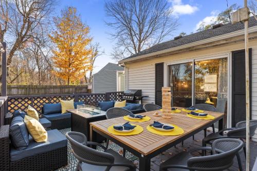a patio with a wooden table and chairs at 3BD Family Retreat - 4 Mins to UND - Yard Games in South Bend