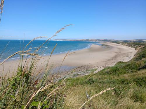 a sandy beach with the ocean in the background at Au Petit Wissant in Marquise