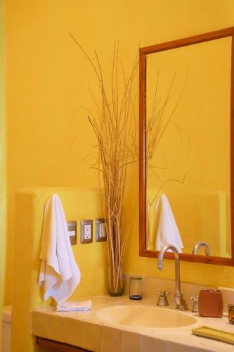 a bathroom with a sink and a mirror at Ensueño de Fuga in Zihuatanejo