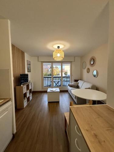 un salon avec un canapé et une table dans l'établissement Les Acacias - Appartement cosy - Plage à 10 min, à Villers-sur-Mer