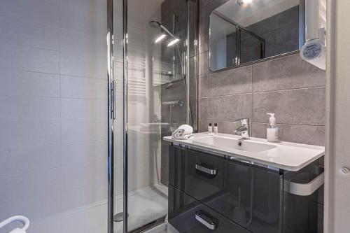 une salle de bain avec un lavabo et une douche dans l'établissement Les Acacias - Appartement cosy - Plage à 10 min, à Villers-sur-Mer