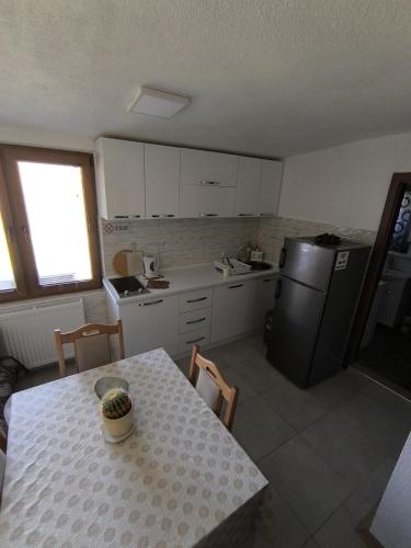 a small kitchen with a table and a refrigerator at Mountain House - Brezovica in Brezovicë