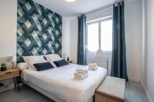 une chambre avec un grand lit avec des serviettes dessus dans l'établissement Les Acacias - Appartement cosy - Plage à 10 min, à Villers-sur-Mer