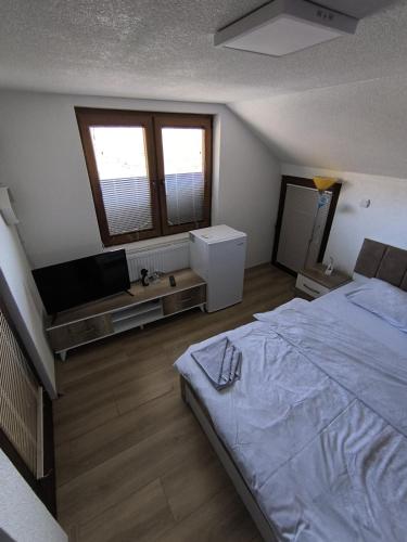 a bedroom with a bed and a flat screen tv at Mountain House - Brezovica in Brezovicë