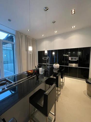 une cuisine avec des armoires noires et une table avec des chaises dans l'établissement Appartement-maison Petite France, à Strasbourg