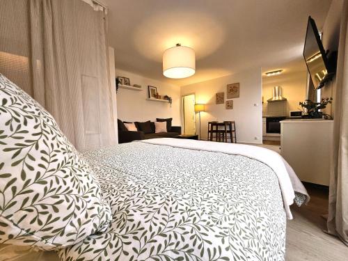 - une chambre dotée d'un lit avec une couverture blanche et noire dans l'établissement Studio Cosy- Hyper Centre Ville, à Colmar