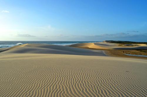 a sand dune with the ocean in the background at Spinguera Ecolodge in Espingueira
