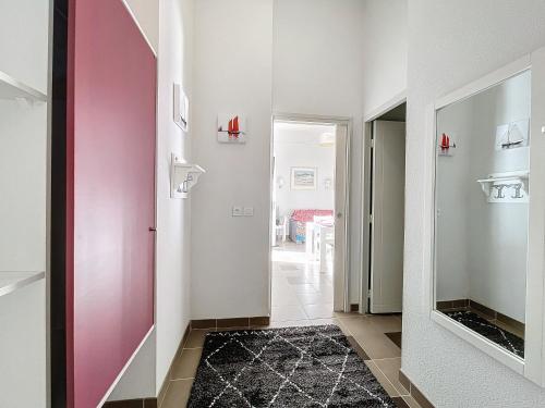 バダンにあるCharmant T3 plain-pied avec terrasse privée, parking gratuit et piscine à Badenのピンクの扉と鏡のある廊下