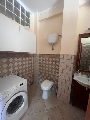 a bathroom with a washer and a toilet and a sink at Arcobaleno 6 in Anzio