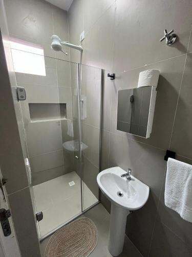 a bathroom with a glass shower and a sink at WeStay Nova Cidade in São Paulo