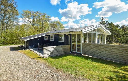 a blue tiny house with a porch at Two-Bedroom Holiday Home In Ringkobing in Ringkøbing