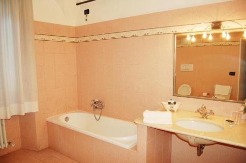 a bathroom with a sink and a bath tub and a mirror at Palazzo Tucci Residenza d'epoca in Lucca