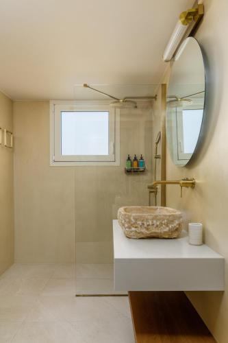a bathroom with a sink and a mirror at Ionian Blue Luxury Apartment in Marathopolis
