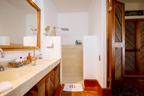 a bathroom with two sinks and a mirror at Ensueño de Fuga in Zihuatanejo