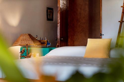 a bedroom with a bed and a table with a lamp at Ensueño de Fuga in Zihuatanejo