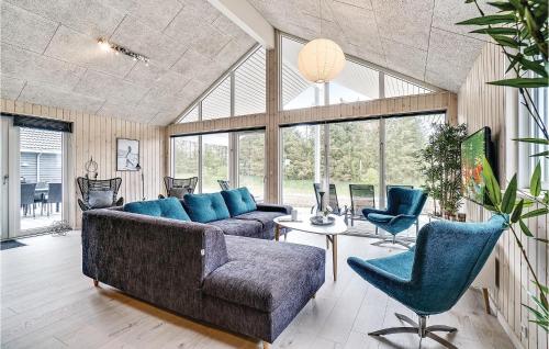 a living room with a couch and a table and chairs at Nice Home In Spøttrup With Sauna in Spottrup