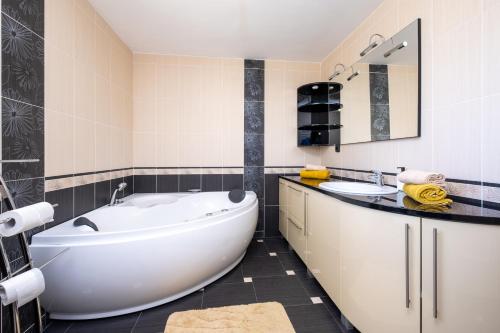 a bathroom with a large tub and a sink at Aurelia in Ðurđekovec