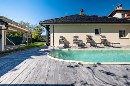a swimming pool with chairs next to a house at Aurelia in Ðurđekovec