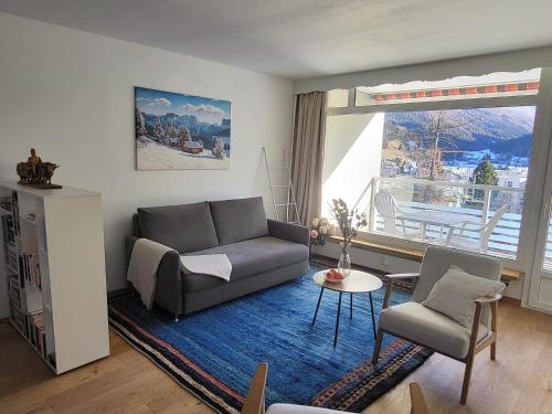 a living room with a couch and a table at Ferienwohnung Parsenn Peaks Panorama in Davos
