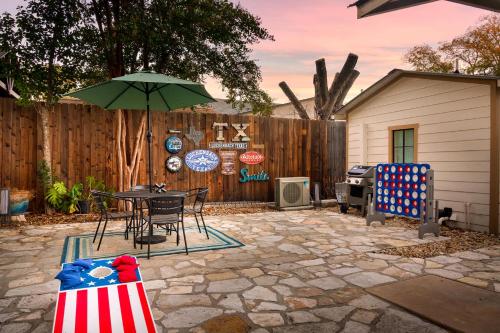 a patio with a table and an umbrella at LeMay Haus - Fire Pit, Heated Pool & Close to Main in Fredericksburg