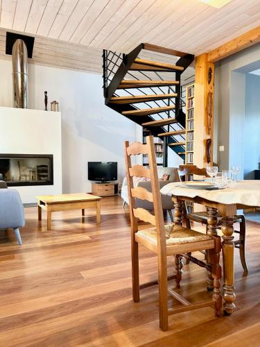 un salon avec une table et un escalier en colimaçon dans l'établissement LAbri-Côtier - Maison chaleureuse - Jardin, à Toulouse