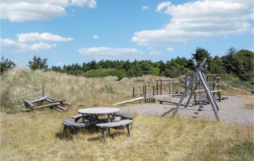 a picnic table and a cross in a field at Amazing Home In Blokhus With Wifi in Blokhus