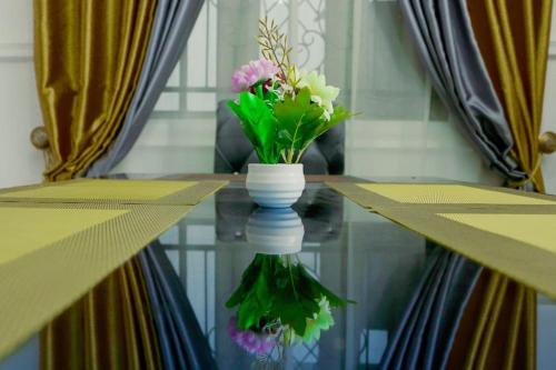 a vase with flowers sitting on top of a table at Frade Apartment in Igbe Ewoliwo