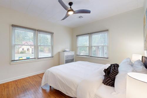 a white bedroom with a bed and a ceiling fan at Marvin's Manor in Stillwater
