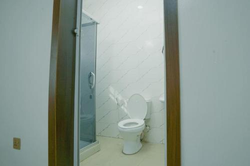 a bathroom with a toilet and a glass shower at Frade Apartment in Igbe Ewoliwo