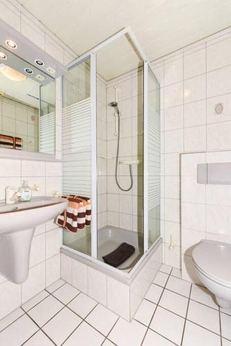 a bathroom with a shower and a sink and a toilet at Bensersiel Ferienwohnung Matrose mit Balkon und Garten in Bensersiel
