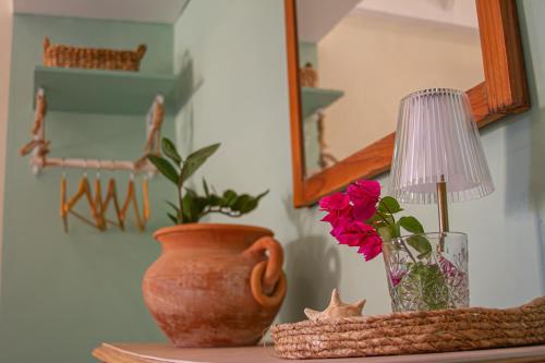 a table with a vase and a lamp and a flower at Landhuis Francia in Willemstad